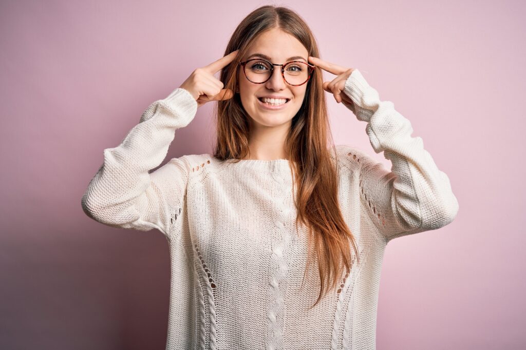 Young woman in sweater wearing glasses